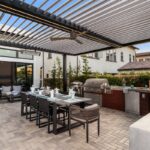 Northern Virginia outdoor living with louvered pergola, outdoor kitchen, built-in grill, pizza oven, and seamless connection to indoor living space