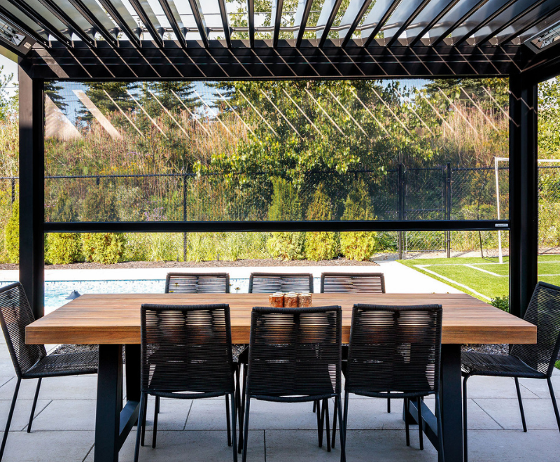 Louvered pergola with Motorized Screen Porch Shades creating a more comfortable covered space