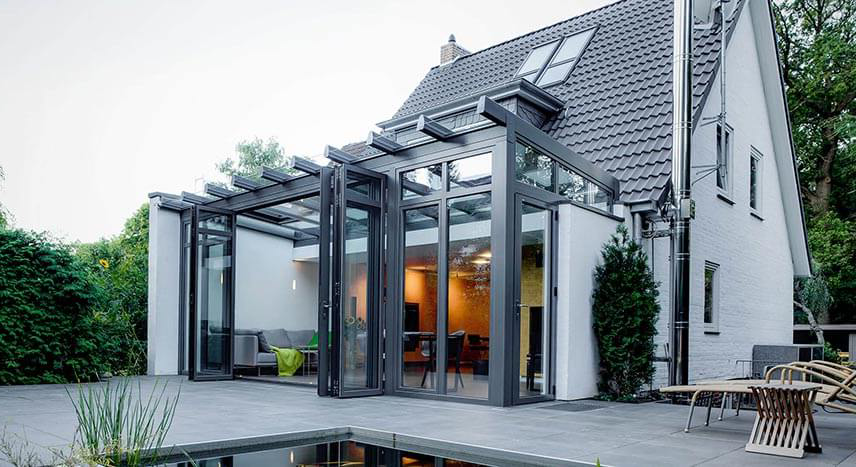 Modern sunroom with large windows, natural light, and contemporary furniture