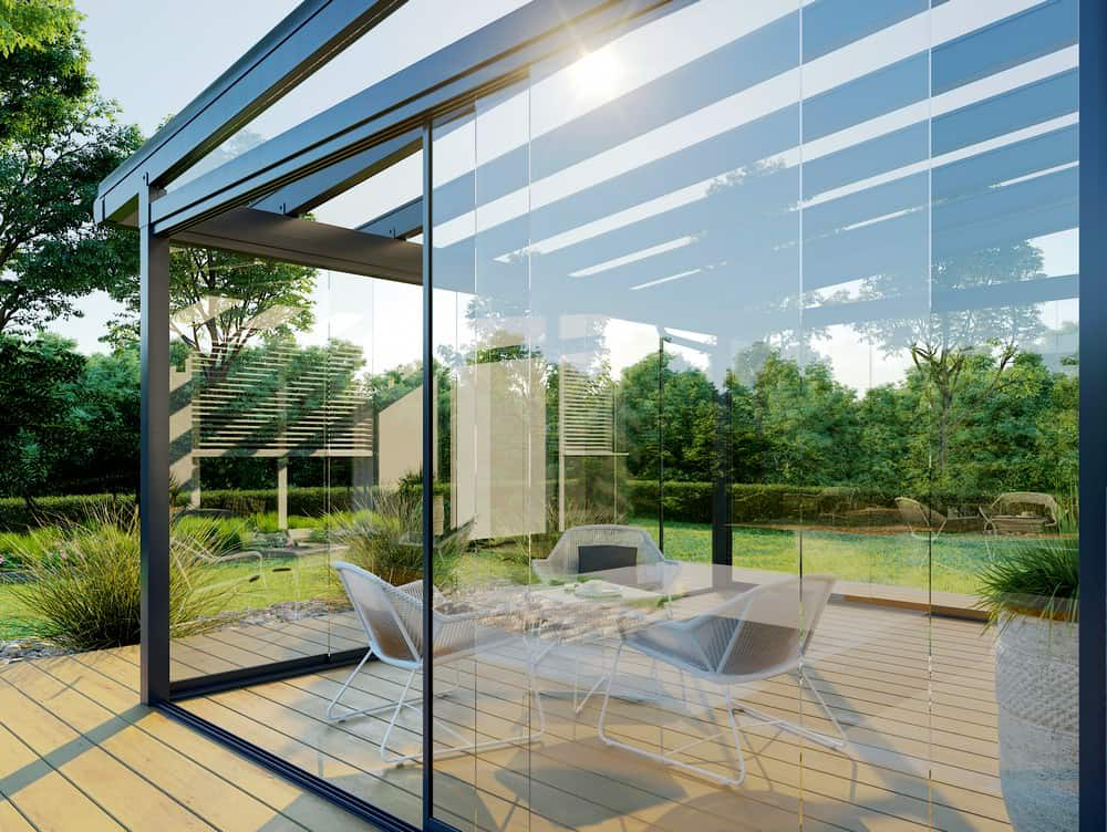 Modern sunroom addition with large glass doors connecting the living space to the backyard